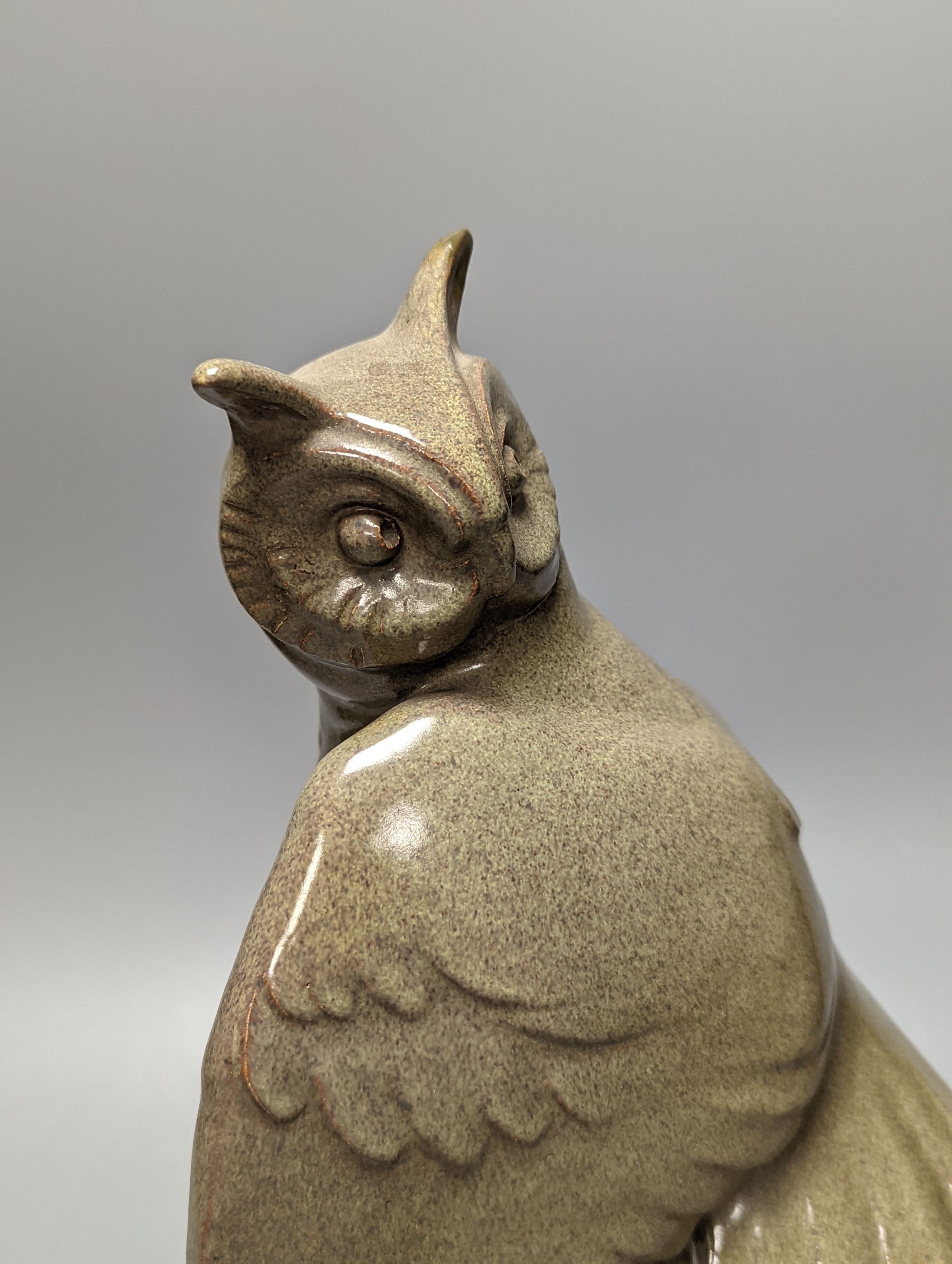 A glazed pottery owl model, 30cm, on wood plinth